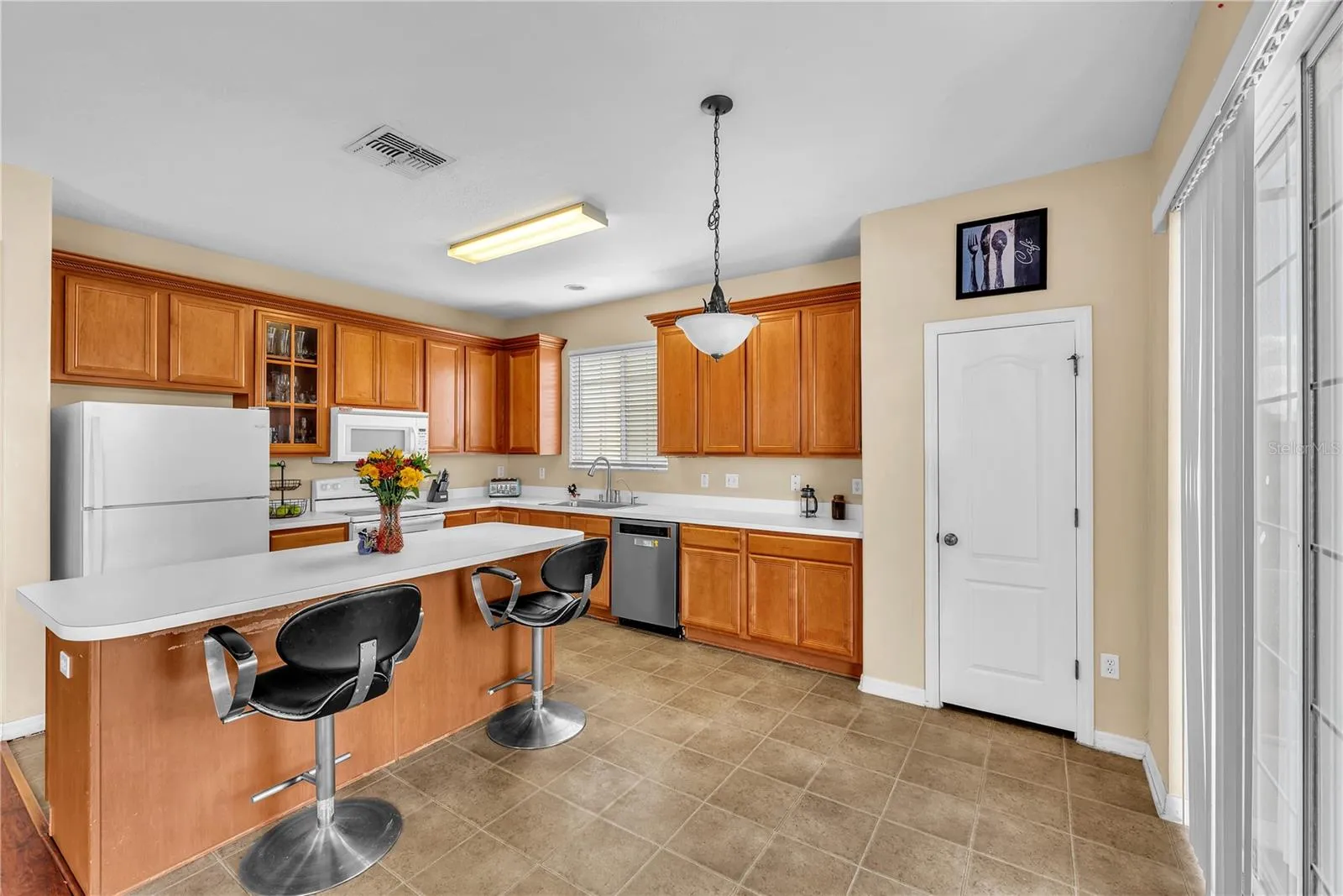At the heart of the home is a huge kitchen featuring an oversized island with breakfast bar seating, abundant workspace, and plenty of room for gathering.