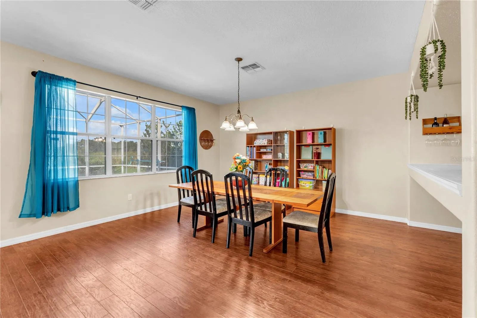 Large window overlooking the pool and lanai flood the dining area with natural light.