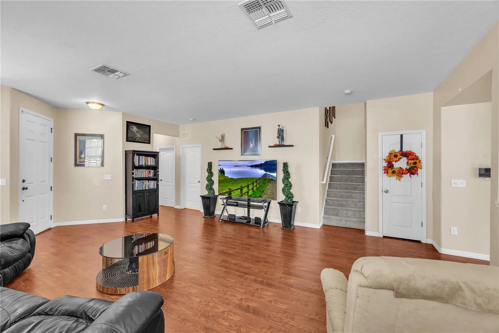 To the left of the TV is a hall leading to a first floor bedroom or flex space and full bathroom.
