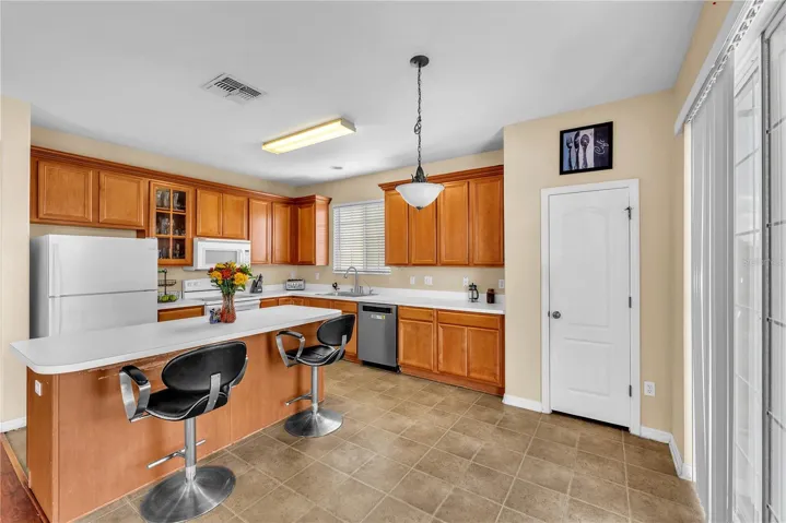 At the heart of the home is a huge kitchen featuring an oversized island with breakfast bar seating, abundant workspace, and plenty of room for gathering.