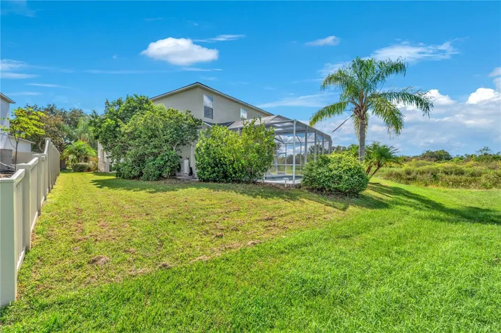 Backyard slopes into conservation area maintained by the HOA.  Neighboring home owns vinyl fence.