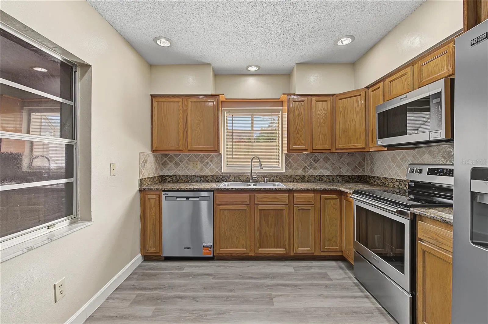 Large kitchen with Stainless Steel Appliances, Patio off to the side.