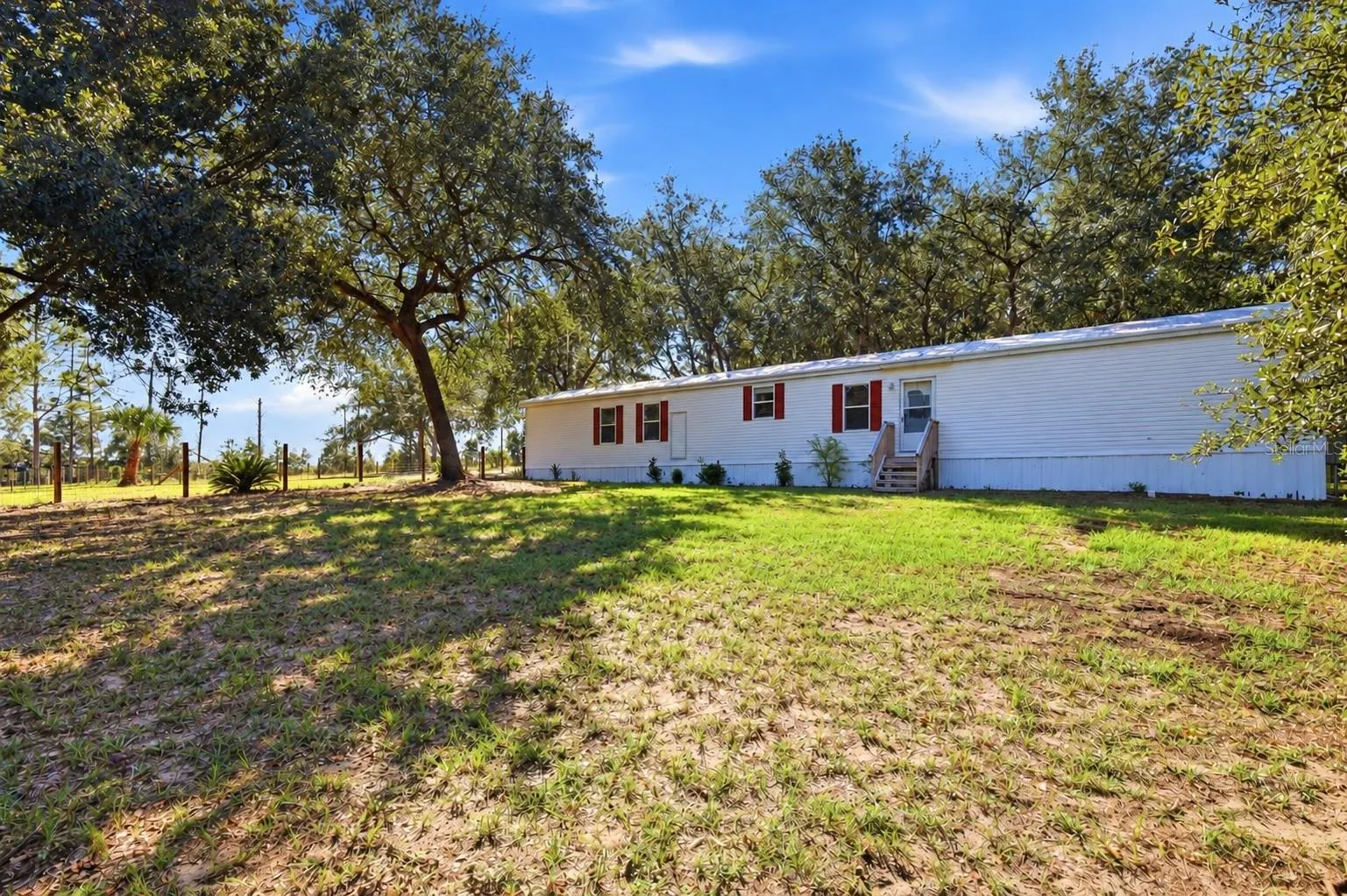 Front of home with 1 of 3 large fenced in area