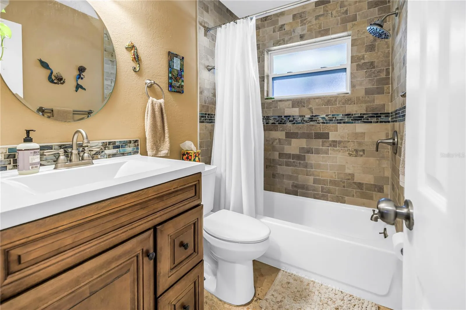 Bathroom featuring travertine, a bathtub with shower and a brand new window.