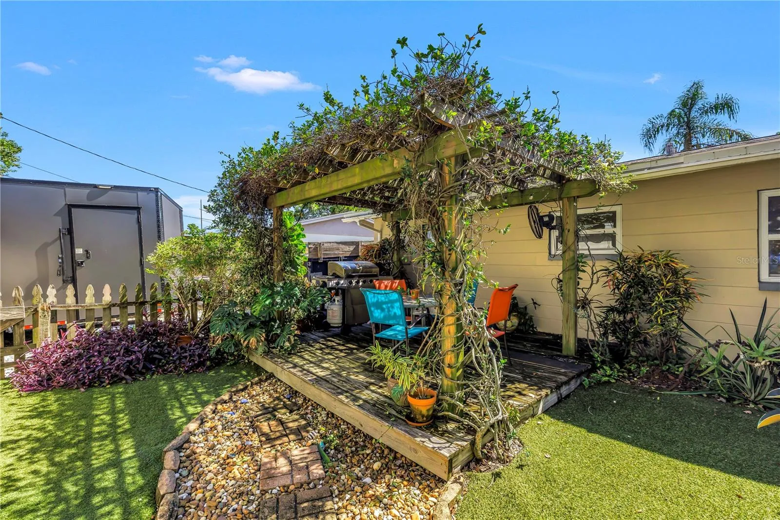 Mature jasmine covers this gazebo, currently a space to grill and dine alfresco.