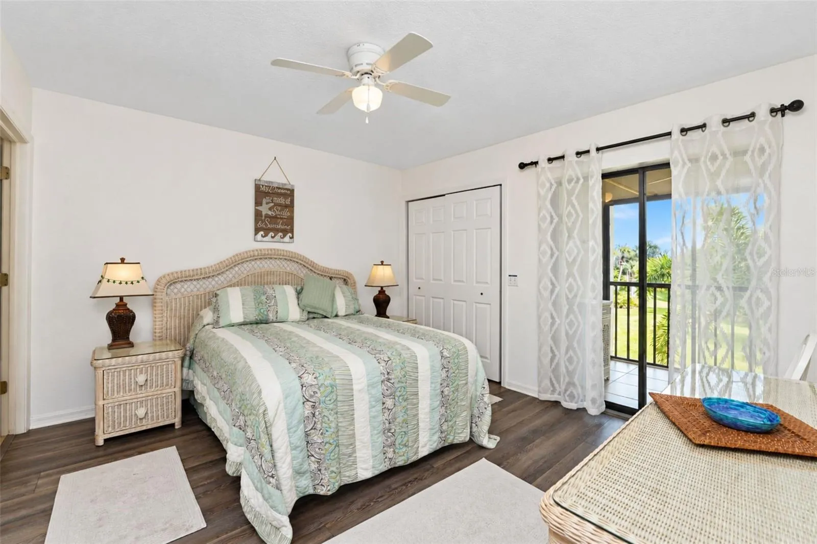 The primary bedroom has new laminate flooring, a ceiling fan, two wall closets and sliding glass doors to the lanai.