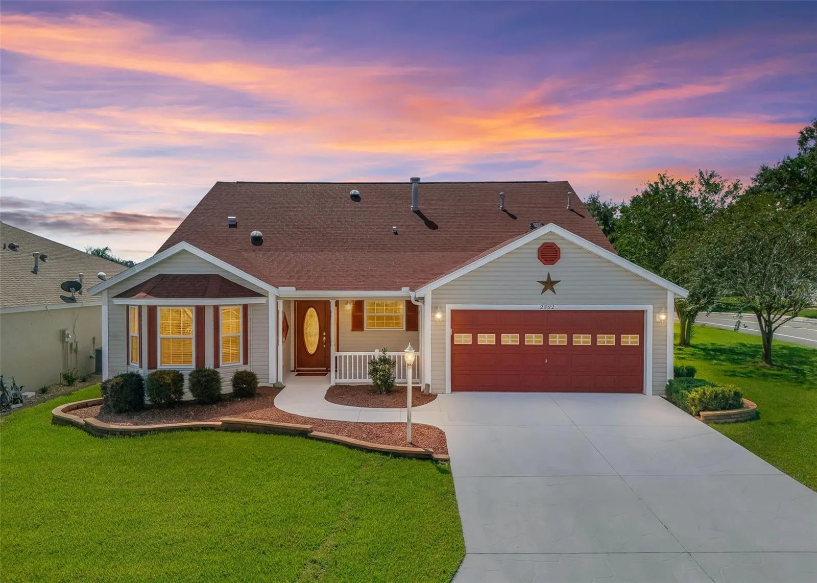 Twilight View with Decorative Pavers, Red Gravel and Low-Maintenance Shrubs.