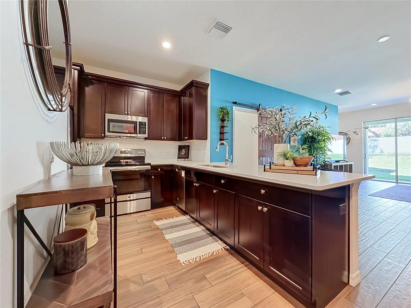 The well-appointed kitchen offers SOLID WOOD CABINETRY, GRANITE countertops, stainless steel appliances, a breakfast bar, and ample storage.