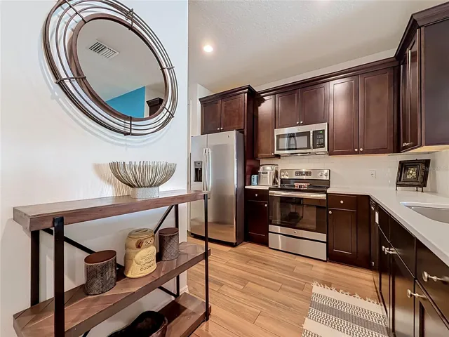The well-appointed kitchen offers SOLID WOOD CABINETRY, GRANITE countertops, stainless steel appliances, a breakfast bar, and ample storage.