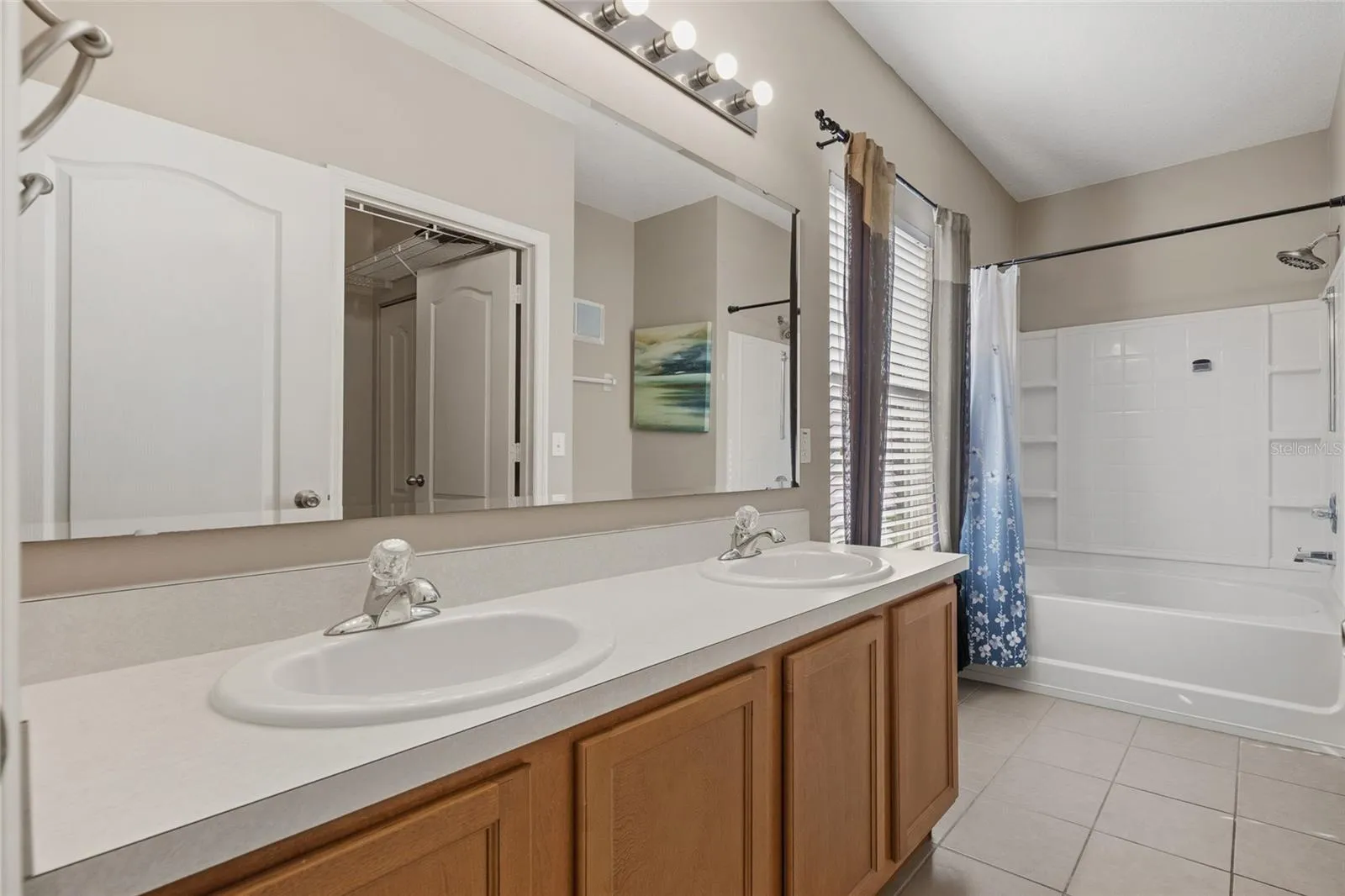 Primary Bathroom with double sinks, tub/shower combo and water closet