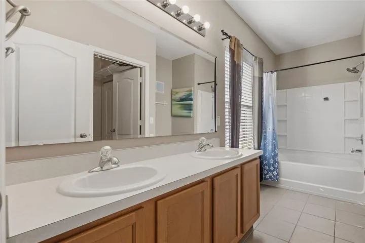 Primary Bathroom with double sinks, tub/shower combo and water closet