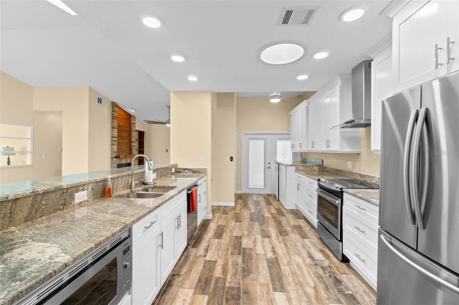 kitchen with open breakfast bar and laundry room with French doors to screened in lanai