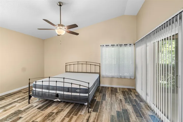 main bedroom with king sized bed and sliders to screened lanai