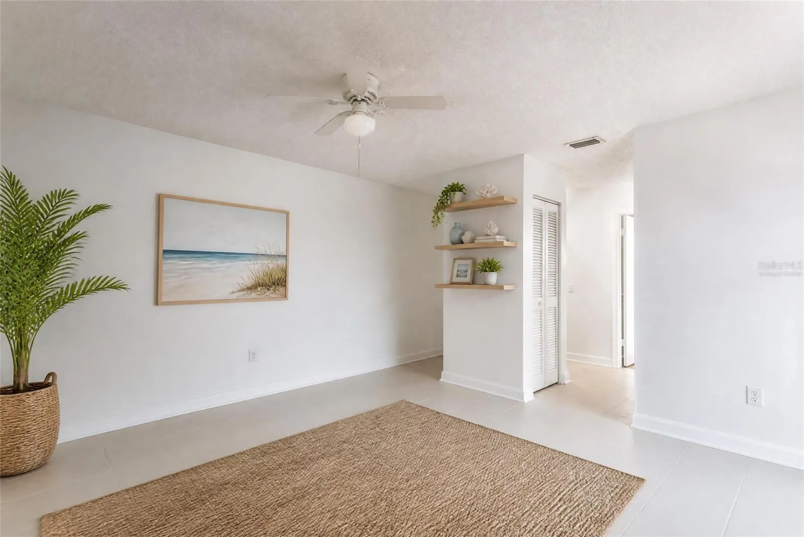 Virtually staged primary suite with tile floors and shelves. Assist in envisioning different flooors
