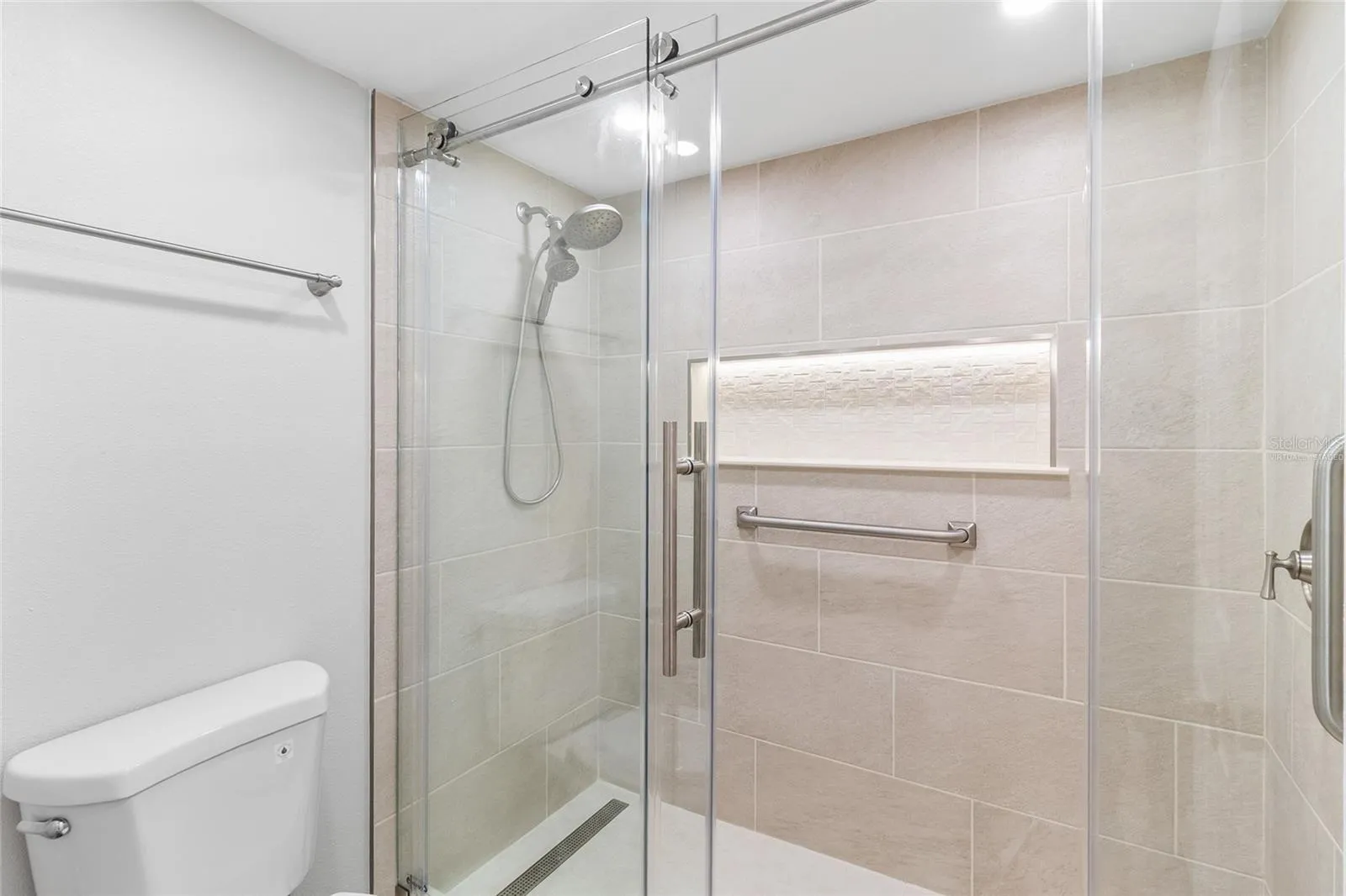 VIRTUALLY STAGED primary bath with updated tile and enclosure