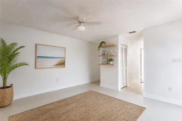 Virtually staged primary suite with tile floors and shelves. Assist in envisioning different flooors
