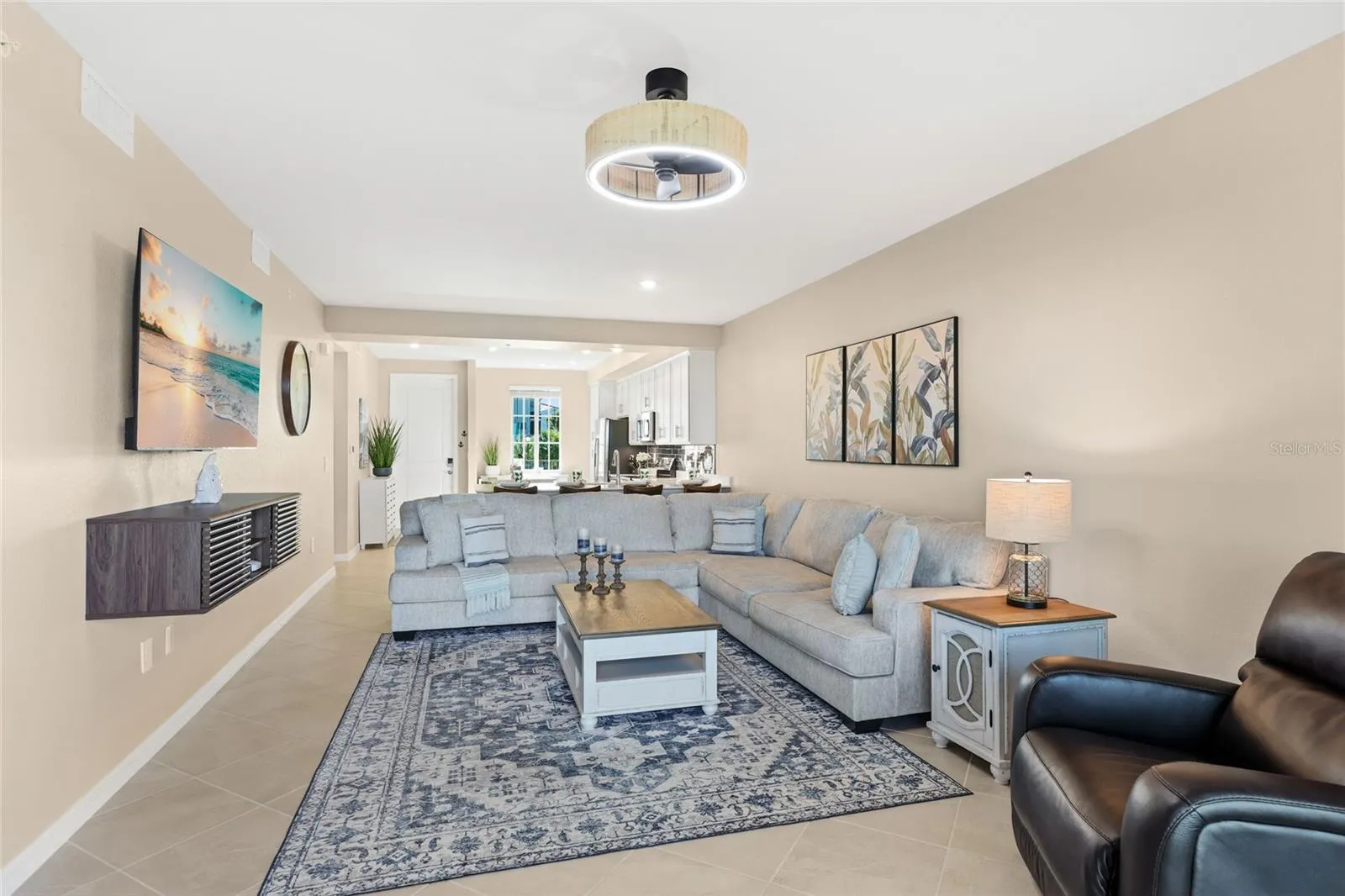 Living Room overlooking the spacious Lanai with beautiful golf course, water, and preserve views.