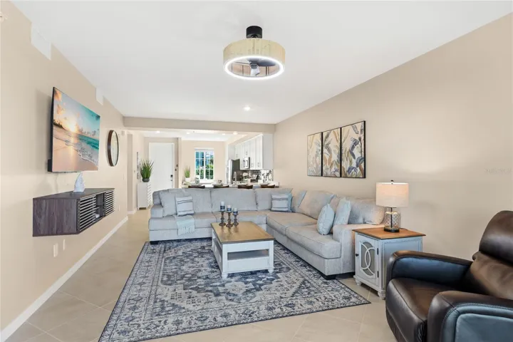 Living Room overlooking the spacious Lanai with beautiful golf course, water, and preserve views.