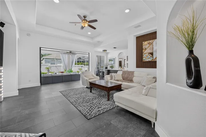 Expansive sliding glass doors open fully, seamlessly extending the living area to the outdoors and creating an ideal space for entertaining.
