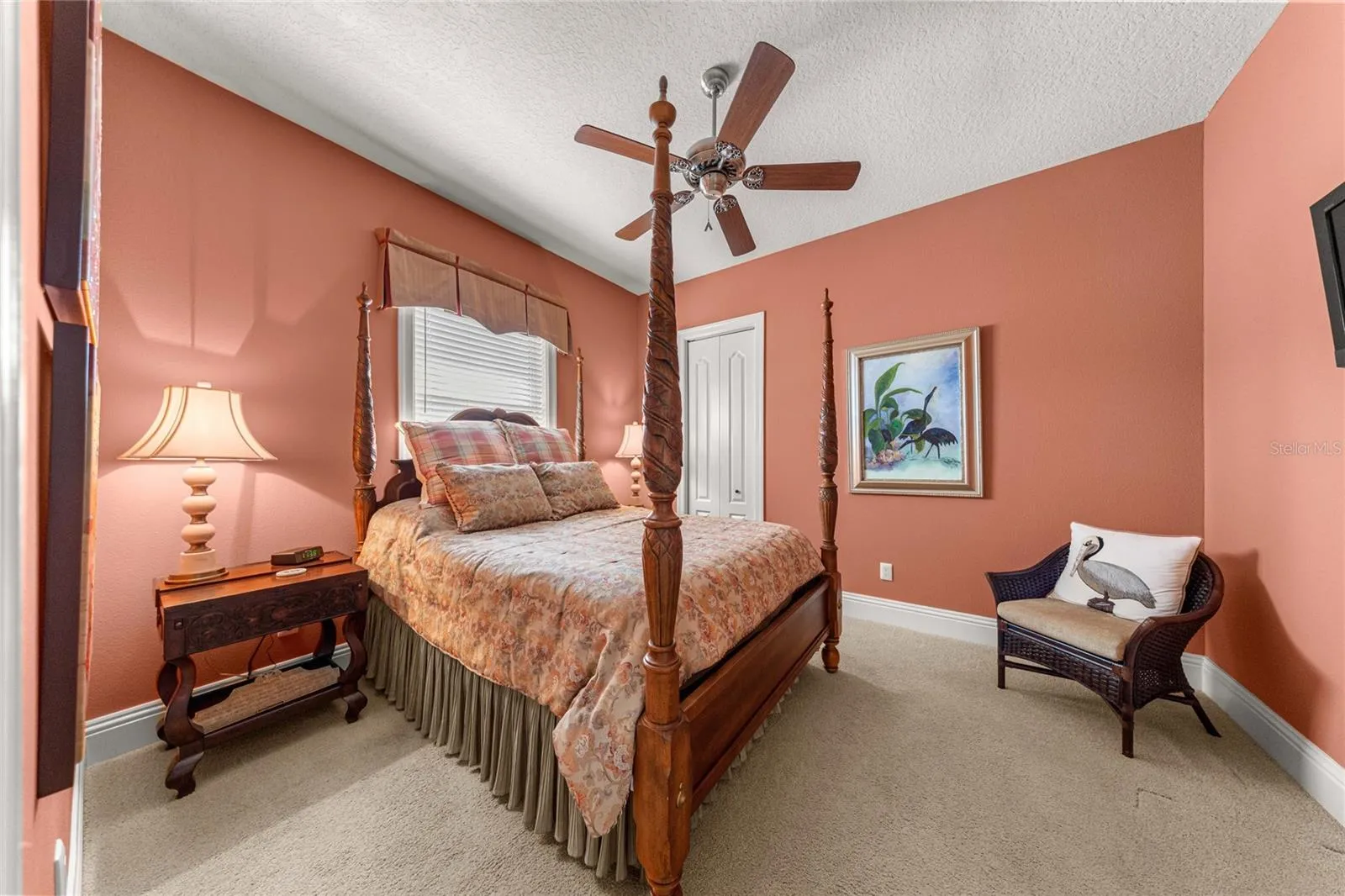 Inviting guest bedroom featuring warm designer colors, plush carpeting, ceiling fan.