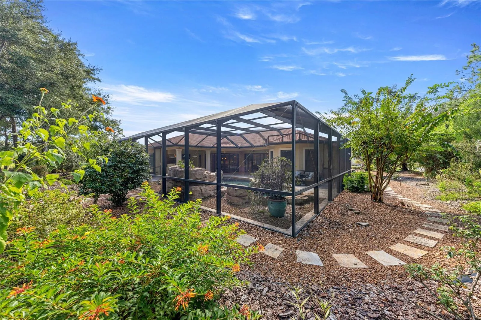 Side Yard – Mature trees, low-maintenance landscaping, and stone walkway.