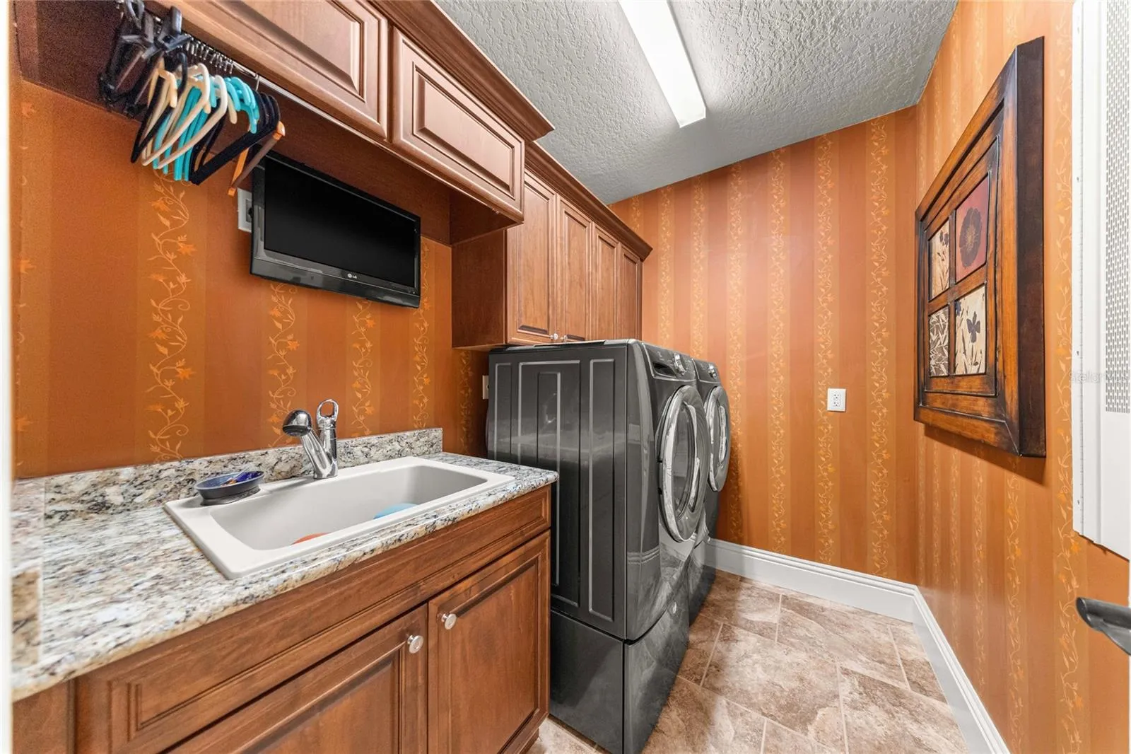 Laundry Room – Built-in wood cabinetry, granite countertop, utility sink, and washer and dryer.