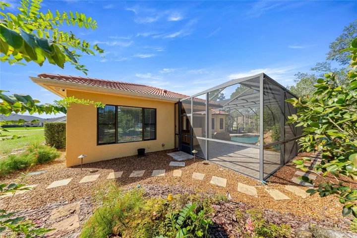 Screened Pool Enclosure – Expansive screened outdoor living area surrounded by natural landscaping.