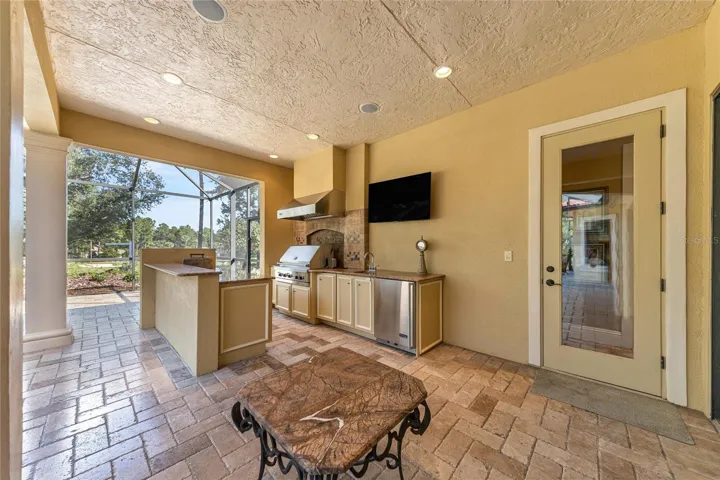 Expansive screened lanai with summer kitchen, custom pool and spa, and plenty of room for outdoor entertaining.