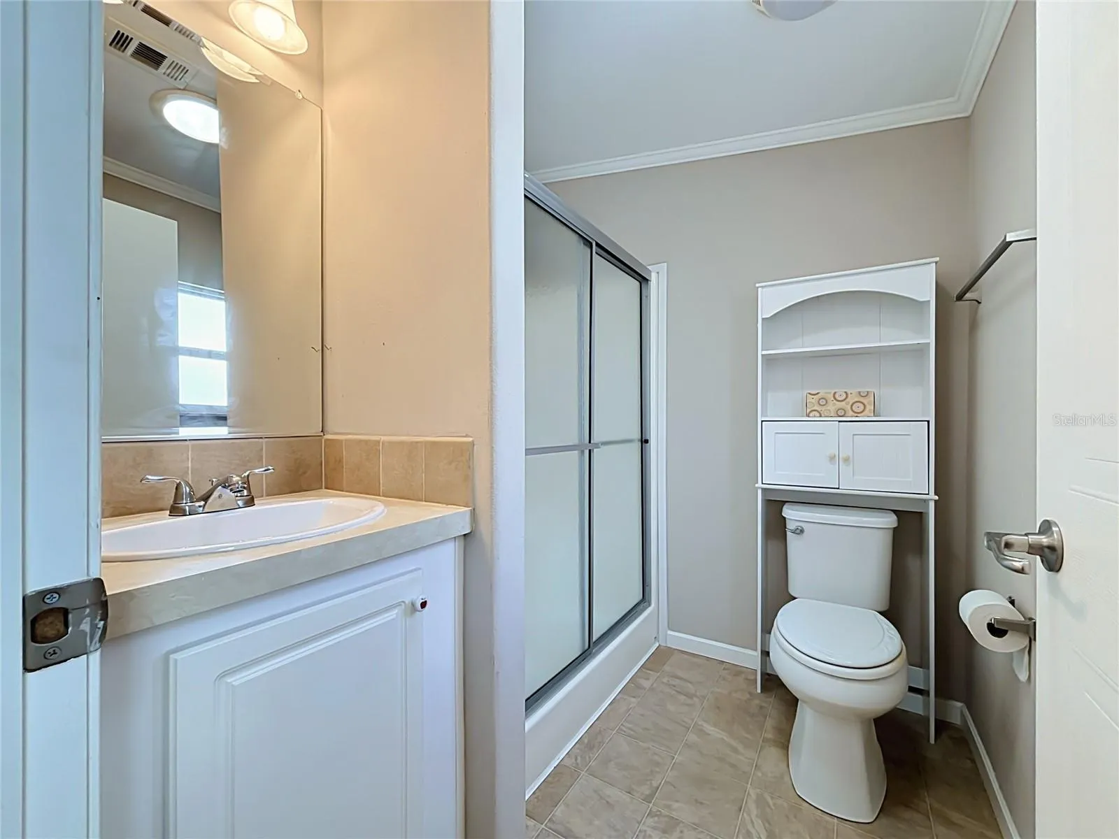 Primary bathroom has walk-in shower and skylight tube allowing natural light to pass through