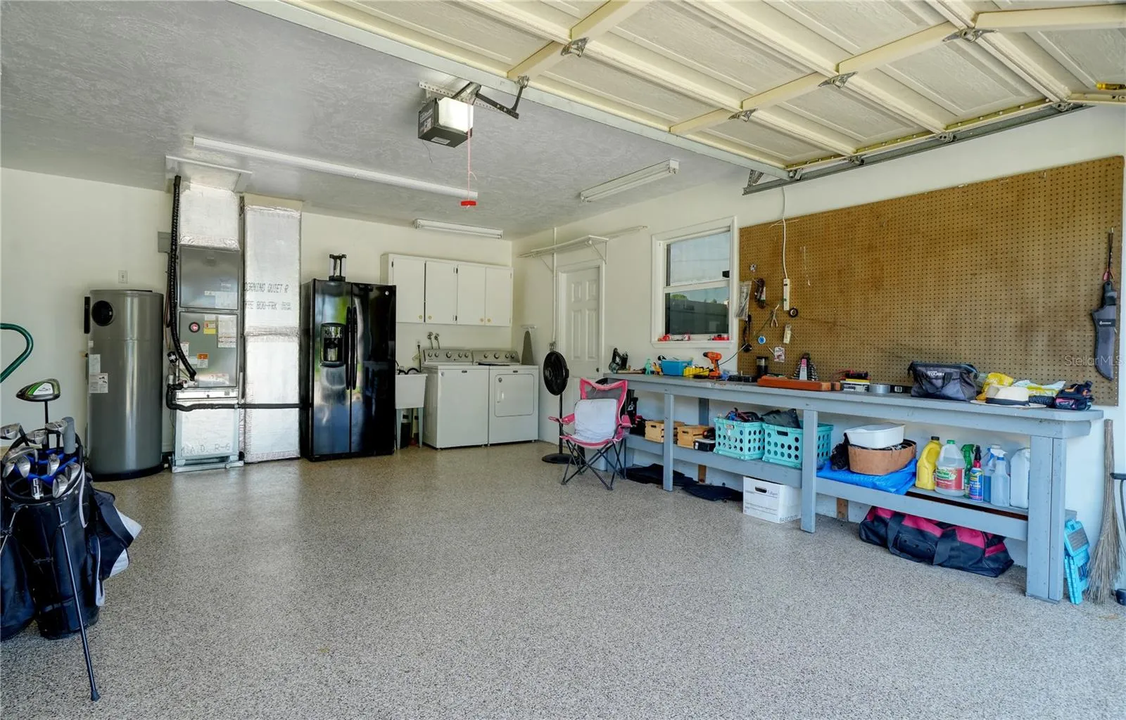Epoxy coated floor in 2 car garage, with laundry and second refrigerator and workbench - side door leads to RV/Boat trailer parking pad behind double door Vinyl fence
