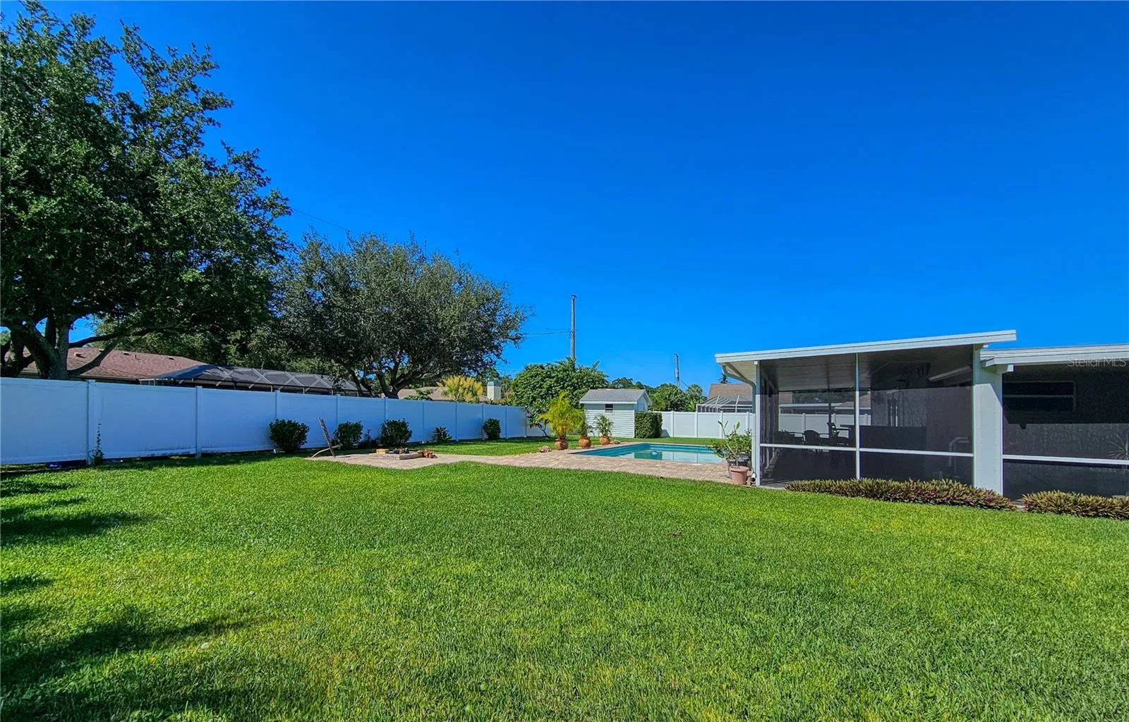 Large side yard behind 6' vinyl privacy fence, room to roam