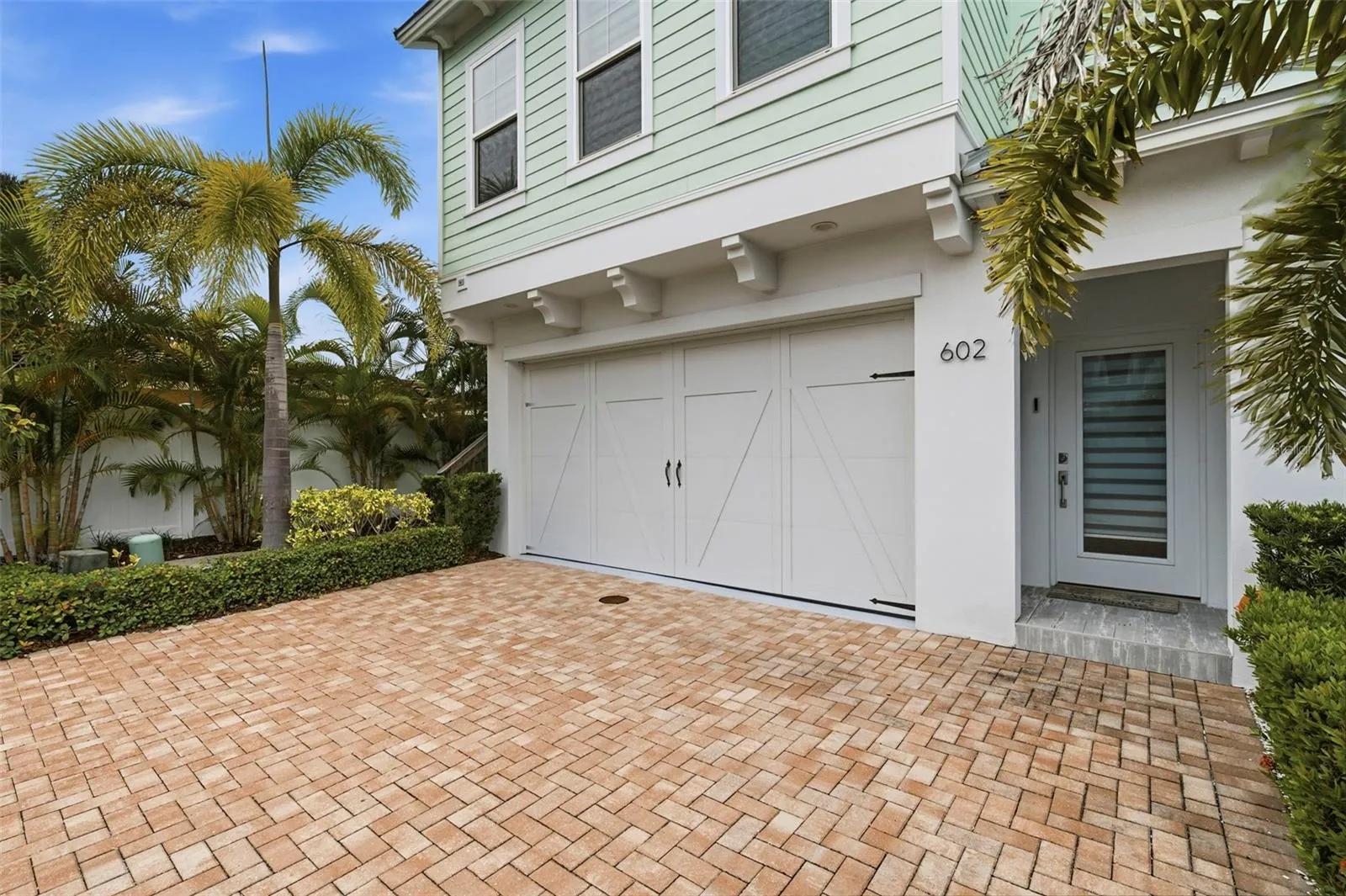 Two car garage with paver driveway for additional parking