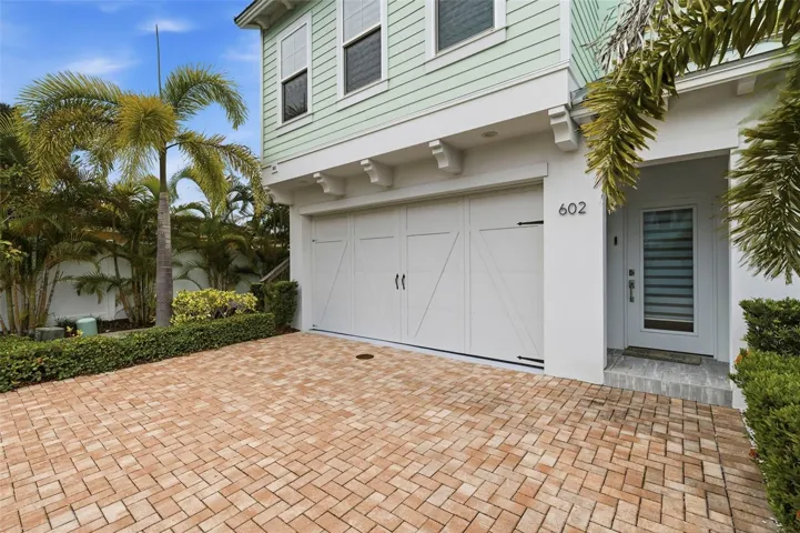 Two car garage with paver driveway for additional parking