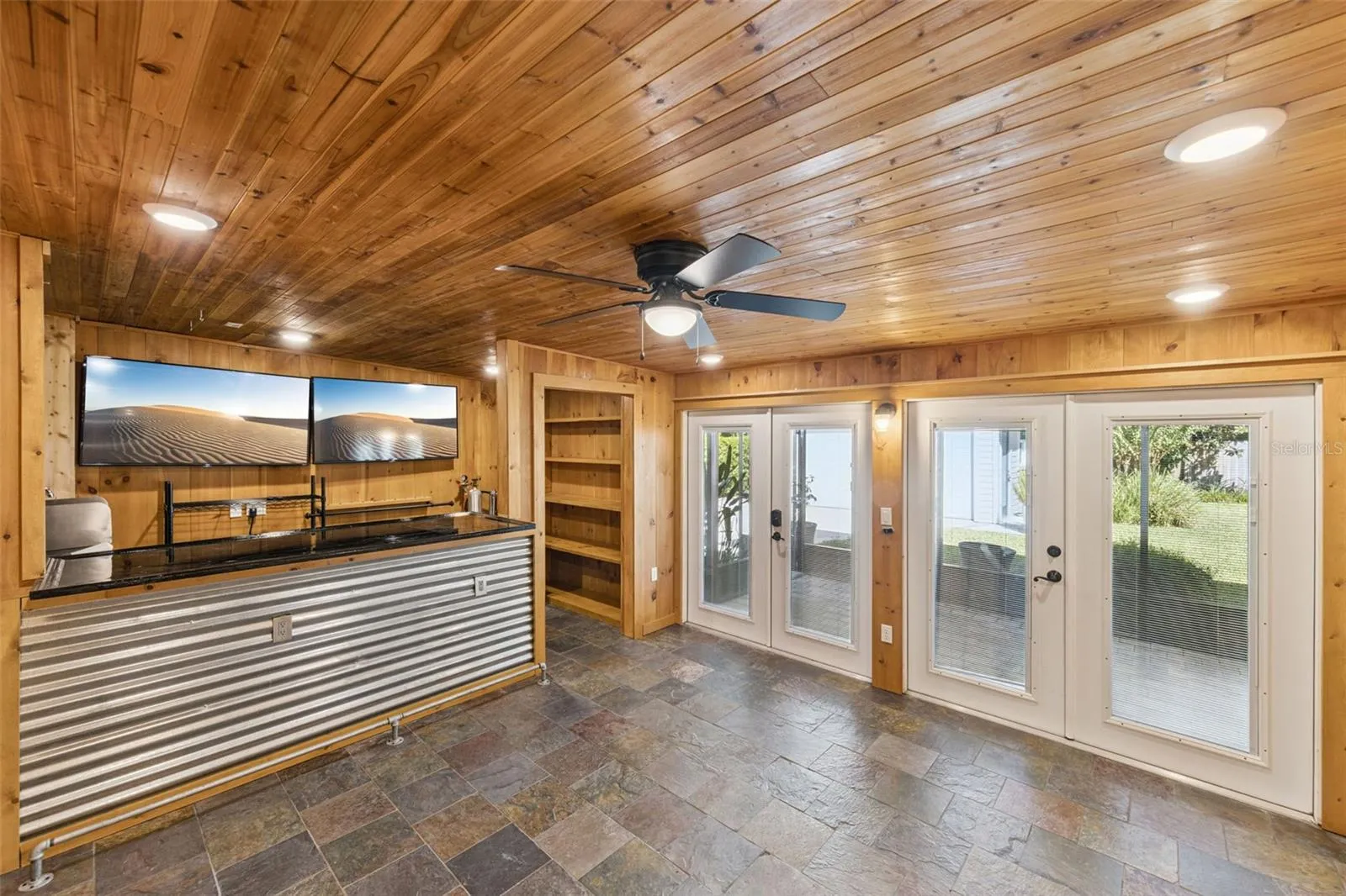 Gameroom has 2 sets of French doors that open into a large screen porch and private fenced backyard.