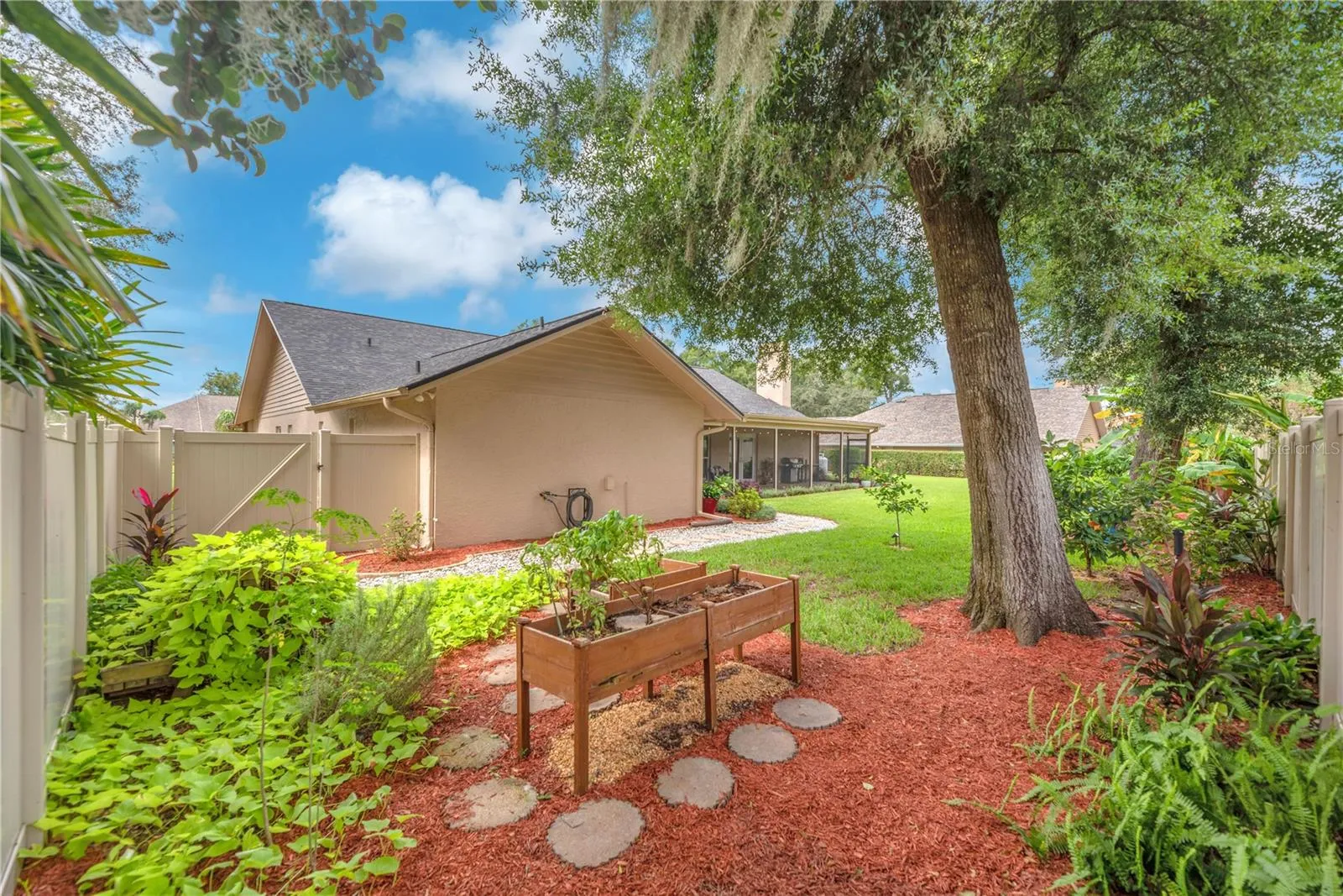 The backyard is partially enclosed with low-maintenance PVC fencing for added privacy and easy upkeep.