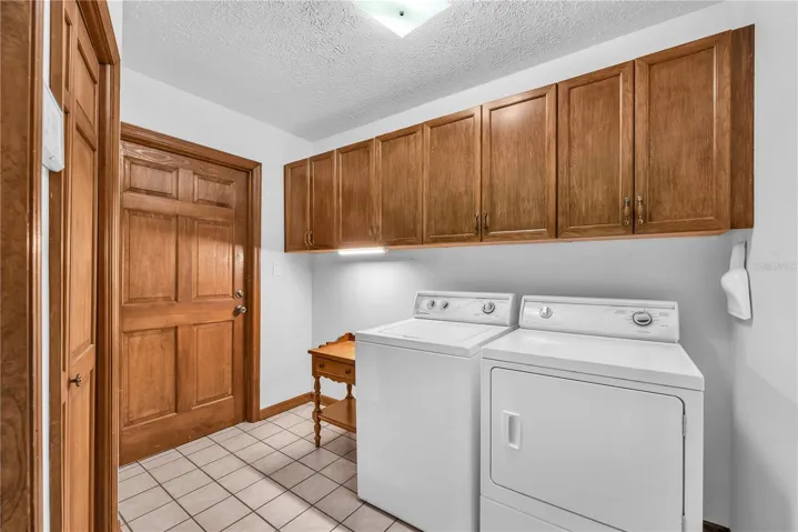 Spacious Laundry room with lots of cabinet storage and garage access.