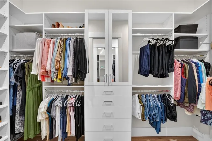 Dual Walk In Closets with Custom Cabinetry and Shelving.