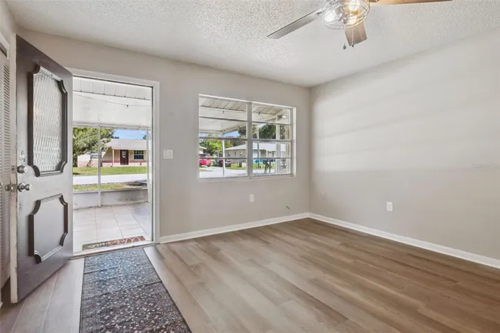 Living Room with ceiling fan and vinyl flooring.