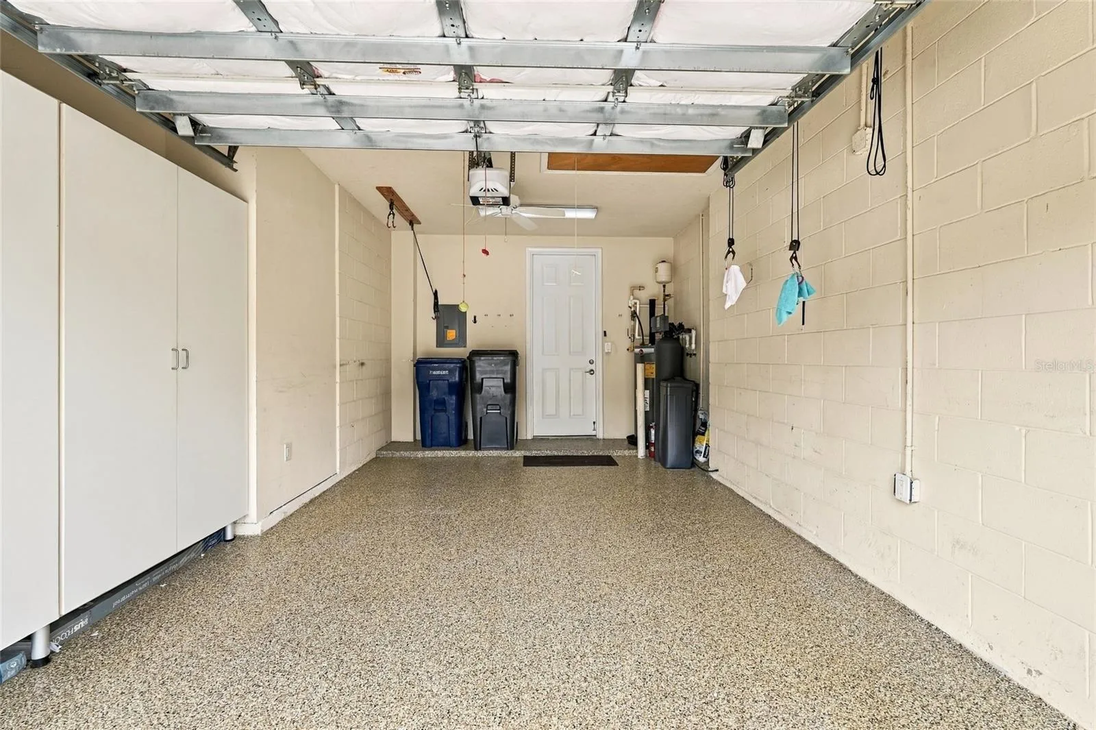 Garage has epoxy floor and storage cabinets