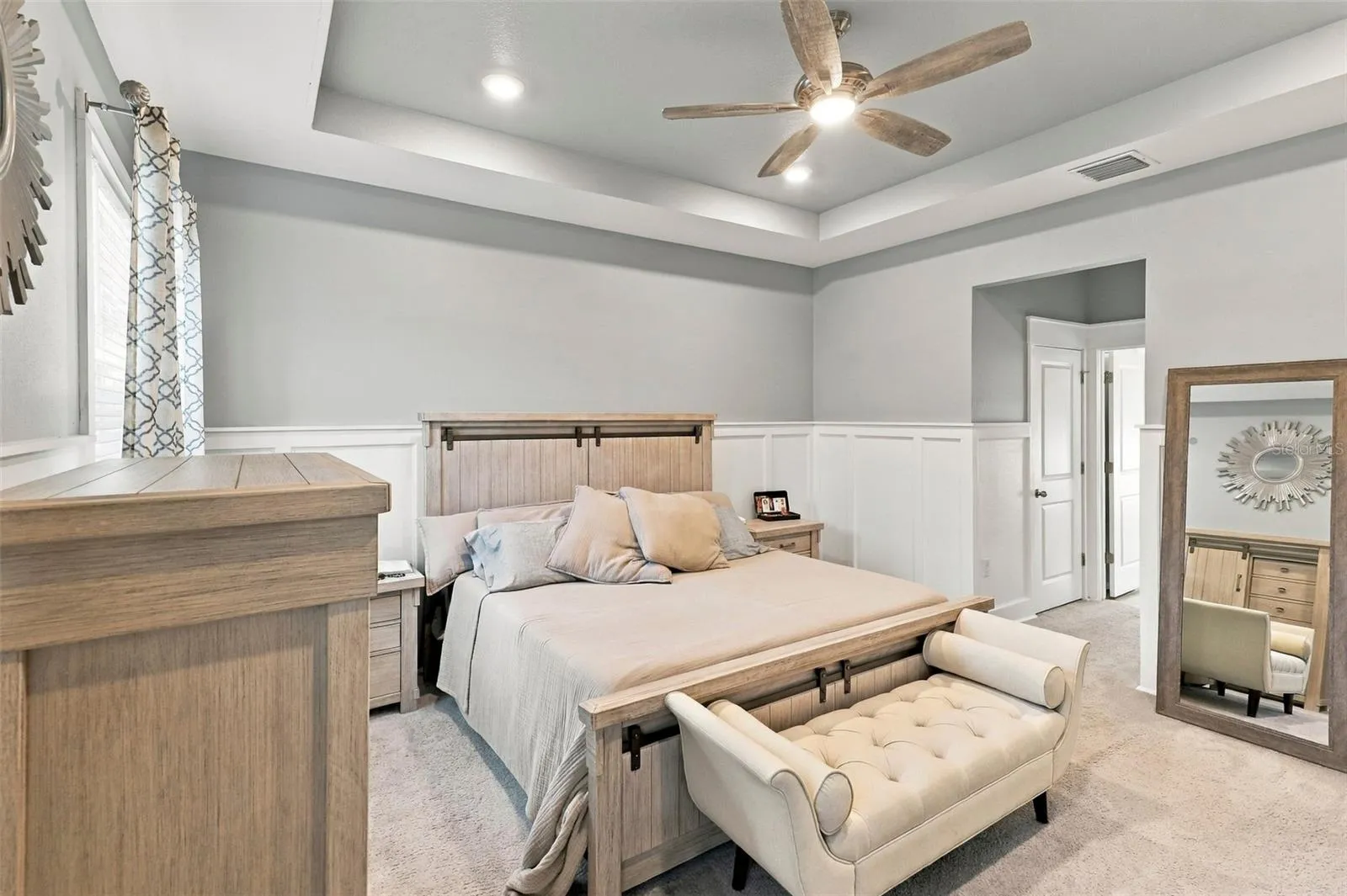 Primary Bedroom with Elegant Tray Ceiling and Ceiling Fan