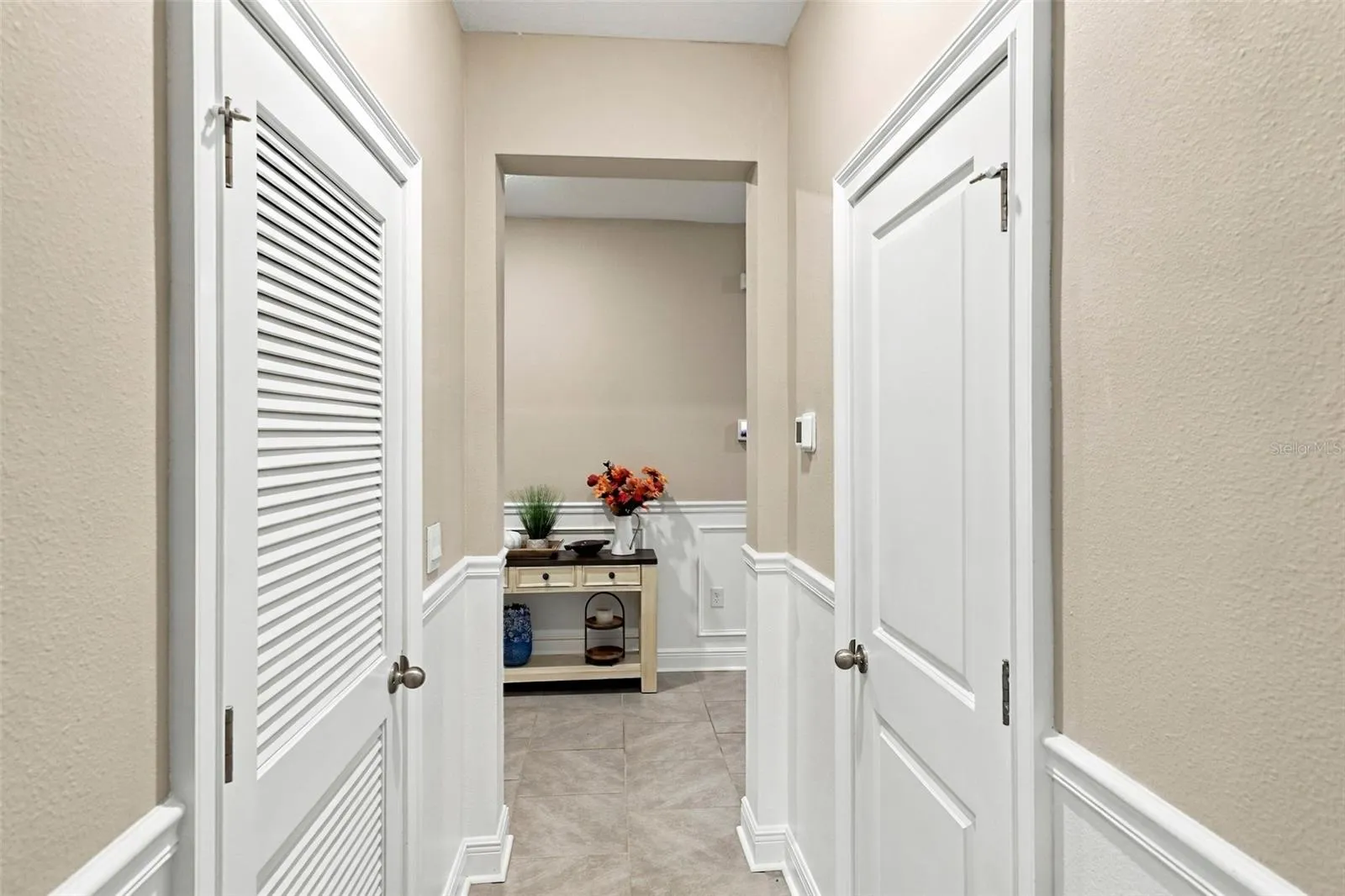 Beautiful Hallway Featuring Decorative Wall Molding and Tile Floor