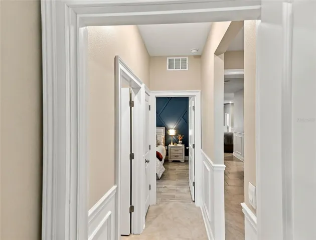 Beautiful Hallway Featuring Decorative Wall Molding and Tile Floor