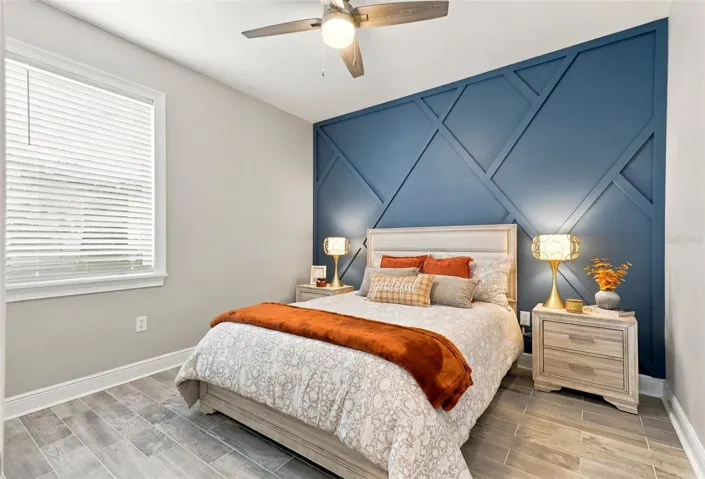Bedroom Featuring a Decorative Blue Accent Wall and Tile Flooring