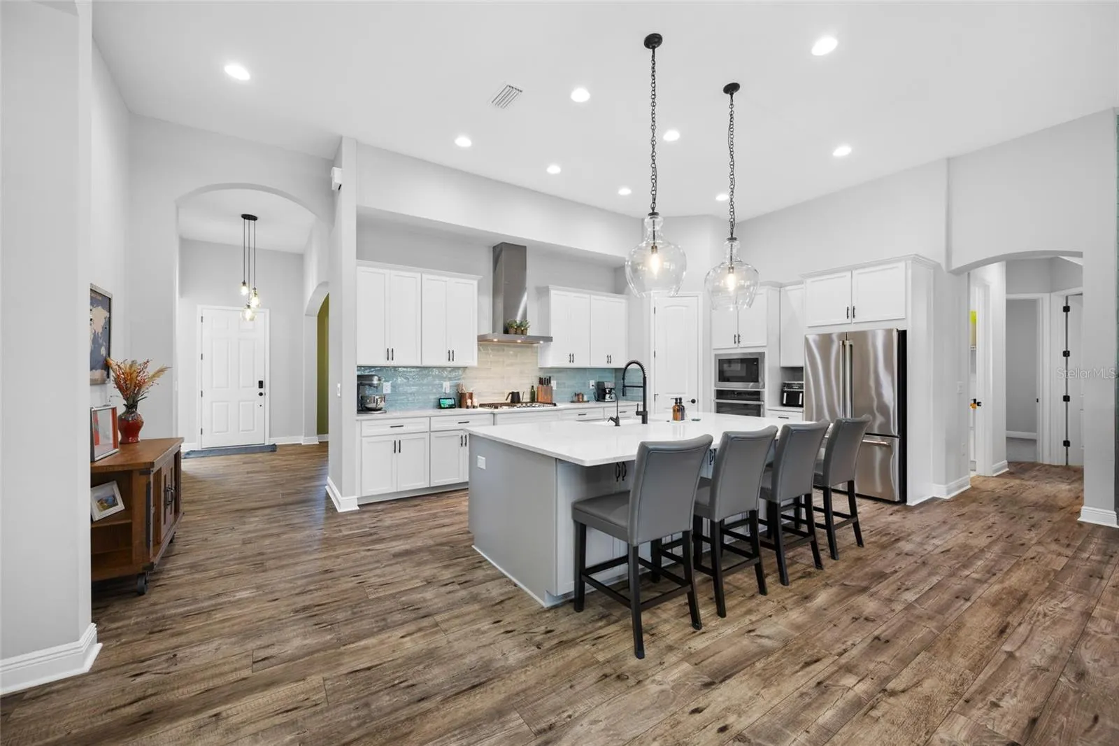 Kitchen with GE Cafe &amp; Profile appliances Gas cooktop &amp; wall oven and 9 foot quartz island