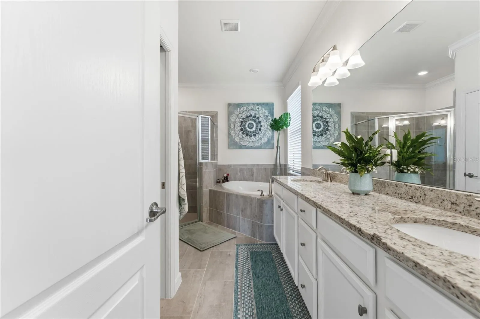 En suite bathroom with dual vanities, garden soaking tub