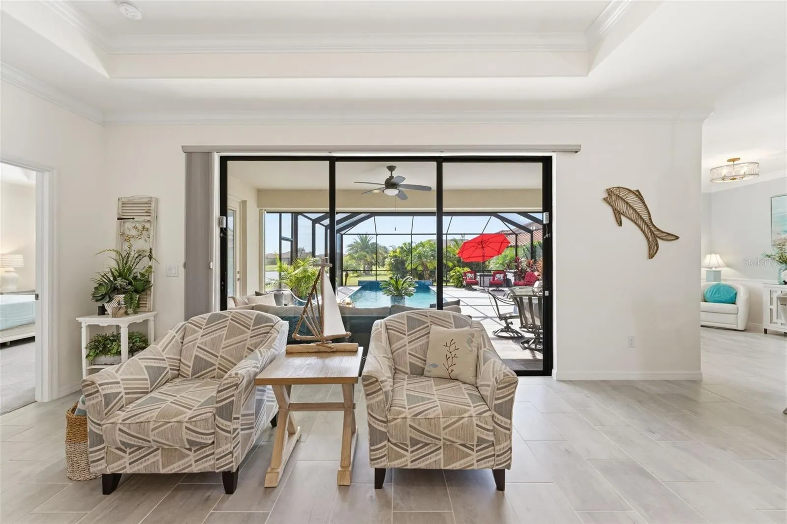 Relax and enjoy tropical pool and lake views through expansive sliding glass doors.