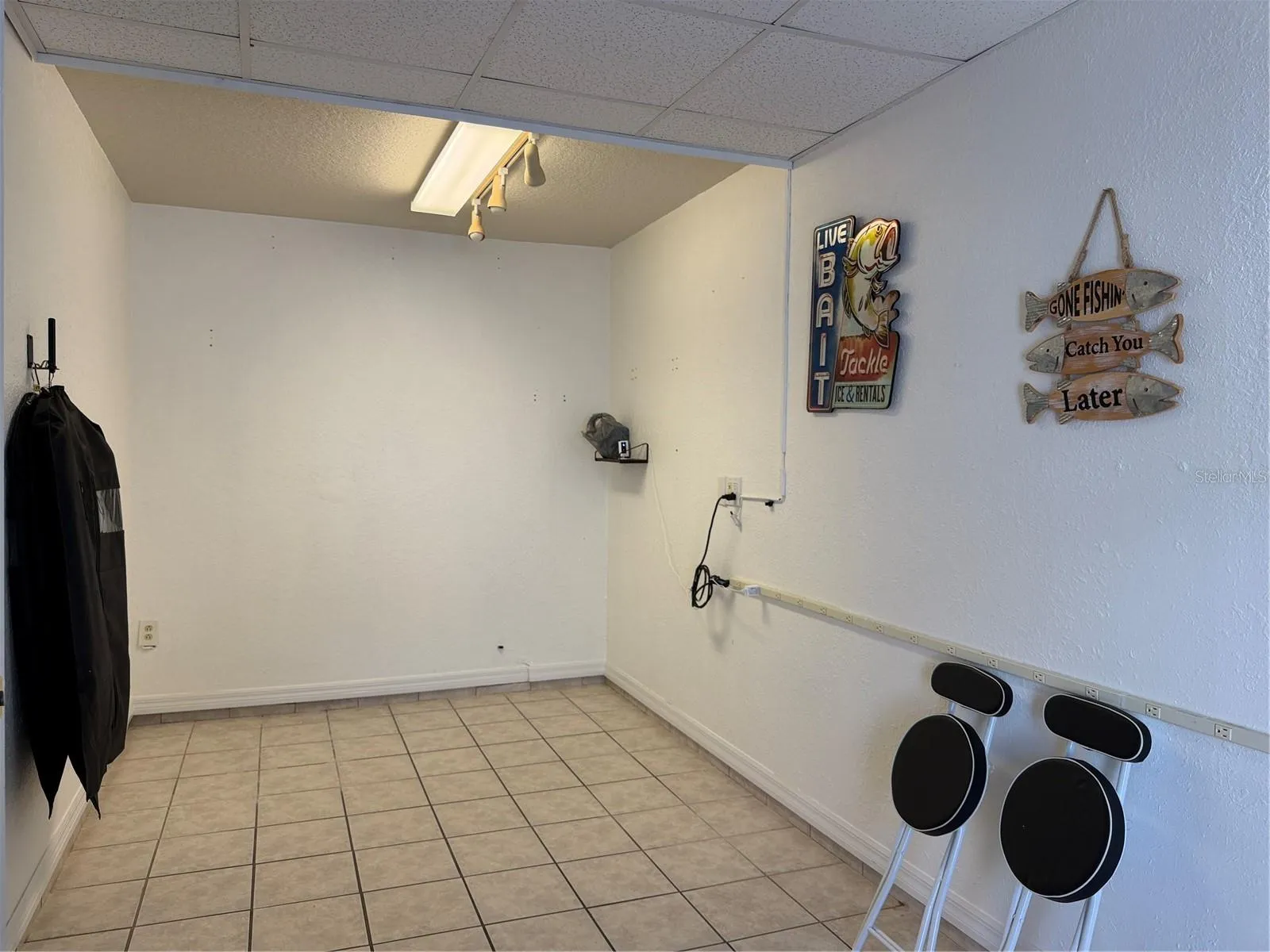 Bonus room in garage has elect plug strip on wall, and tile  flooring