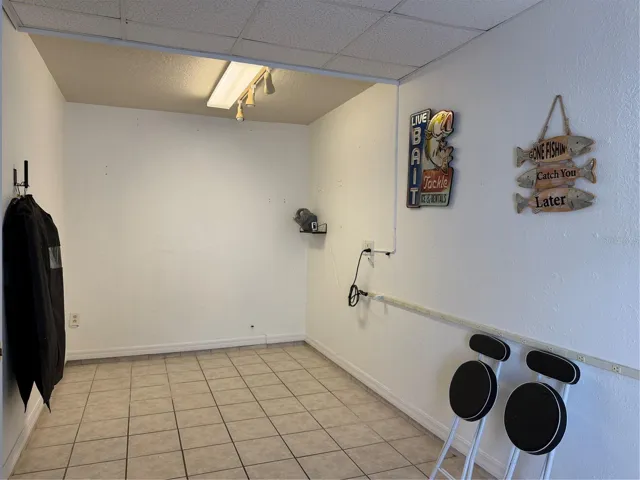 Bonus room in garage has elect plug strip on wall, and tile  flooring