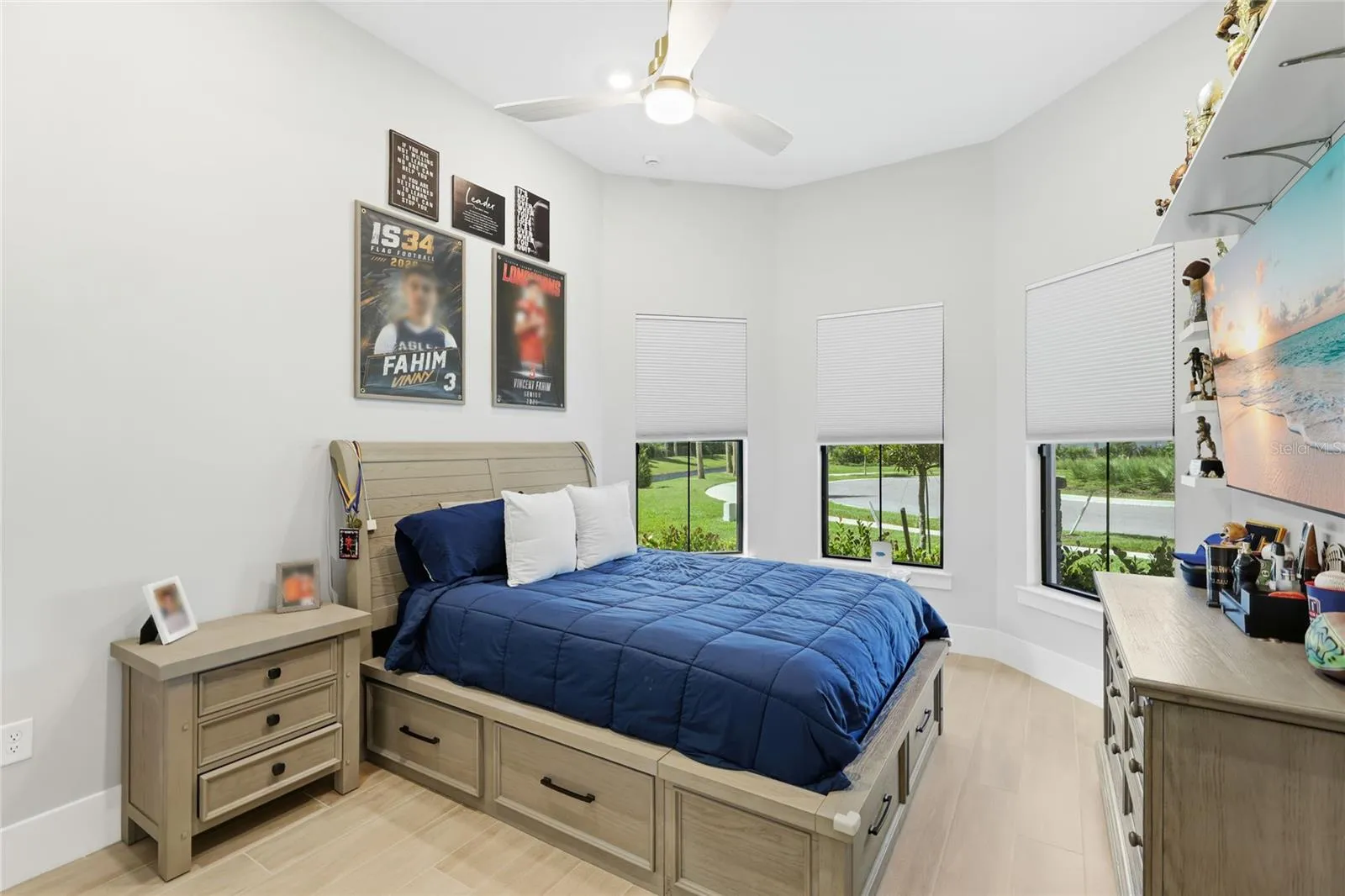 Bedroom 2 with front bay window, ceiling fan, built-in closet with lighting.