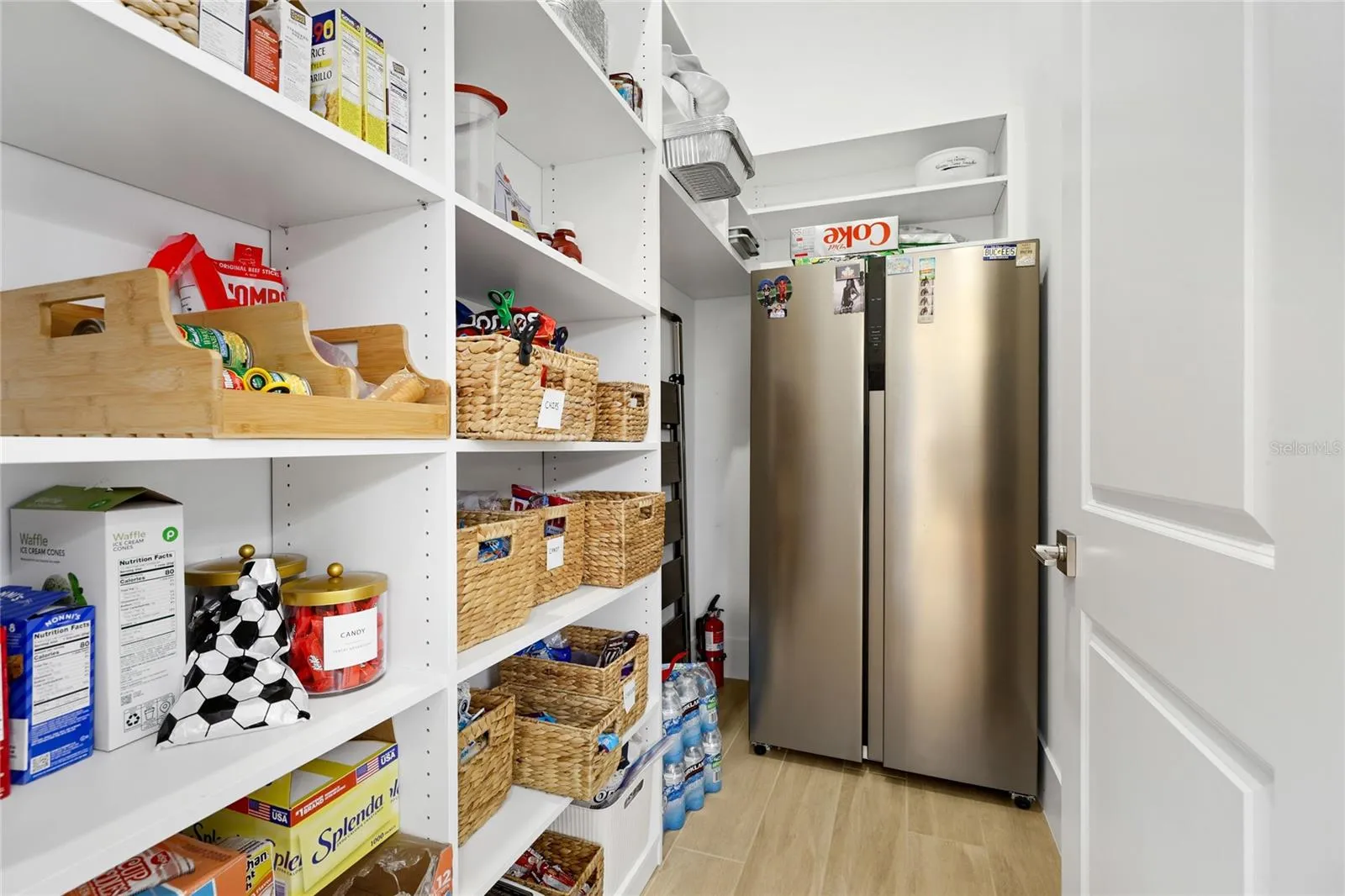 Pantry with custom built in shelving that  accomodate an additional refrigerator.